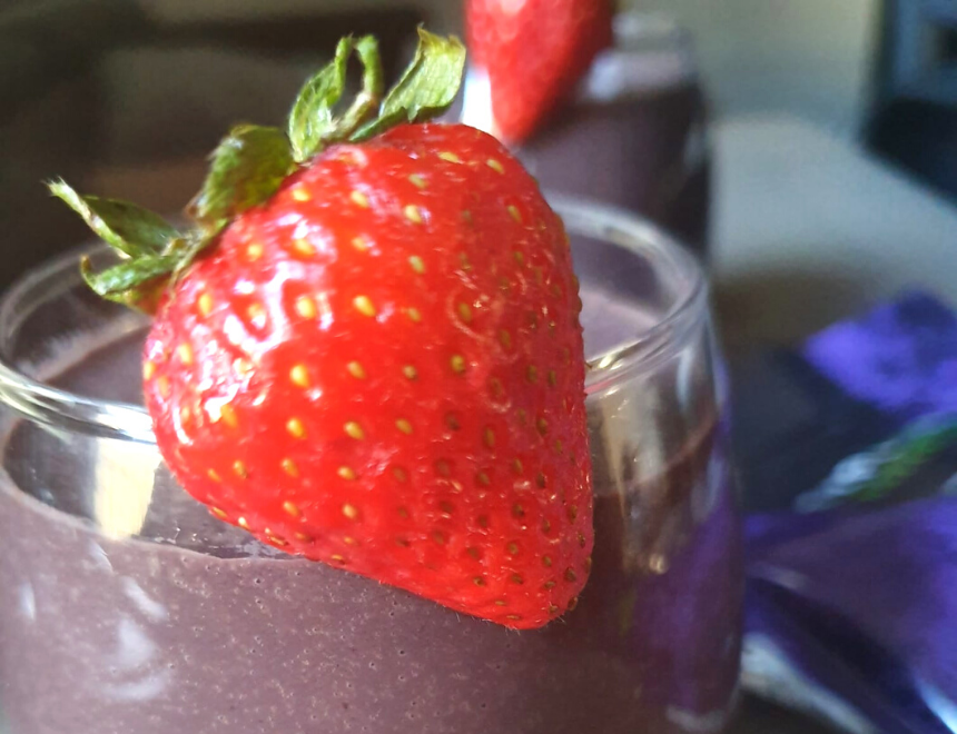 healthy acai fruit smoothie with a bright red strawberry garnish